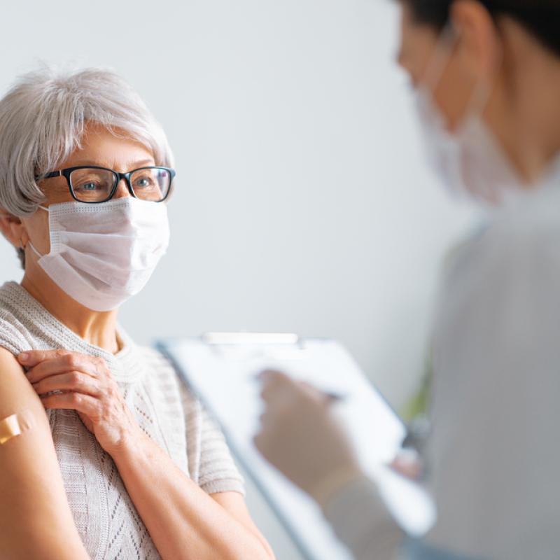 Patient with mask on being vaccinated