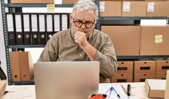 Man coughing at desk