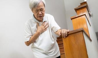 older asian woman clutching at chest