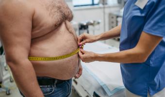 Obese man having his waist circumference measured