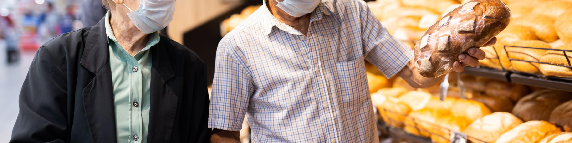 Elderly couple with masks on shopping in a supermarket